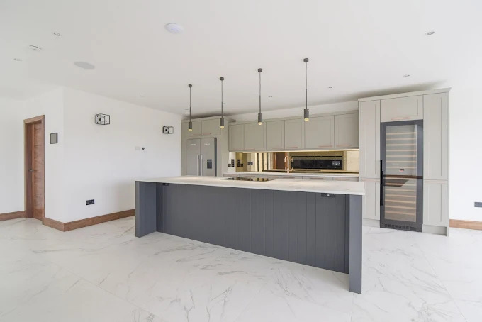 Large fitted kitchen with sage cabinets and feature island by SES Renovations