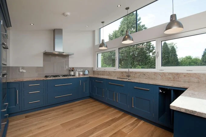 Modern fitted kitchen with sage green shaker cabinets, white quartz island and brushed brass handles by SES Renovations