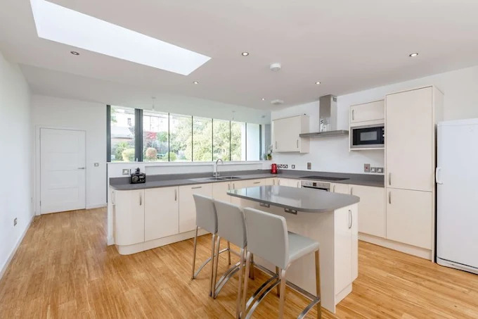 Cream shaker kitchen with island and skylight by SES Renovations