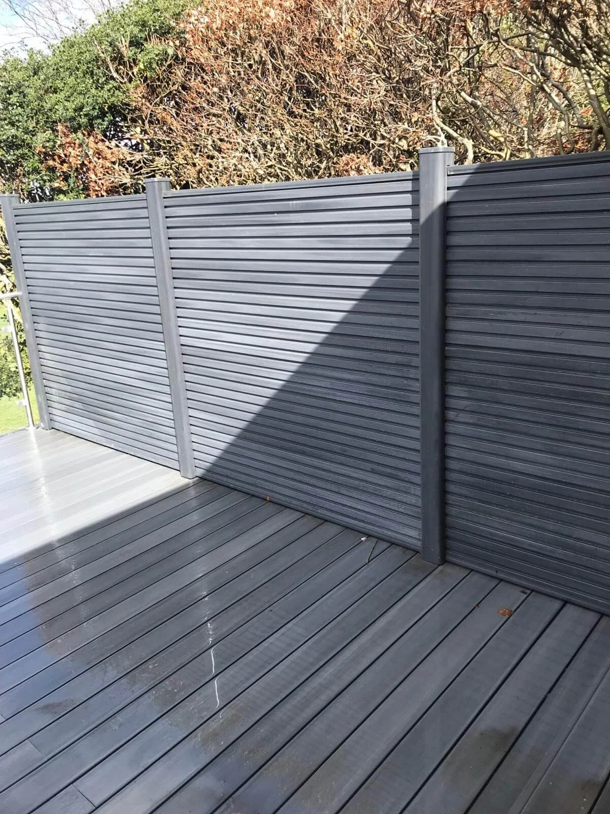 Composite decking framed by slatted fencing